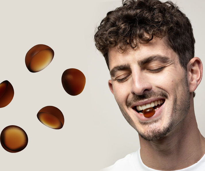 Man with closed eyes and a smile, with black seed gummies on a light gray background