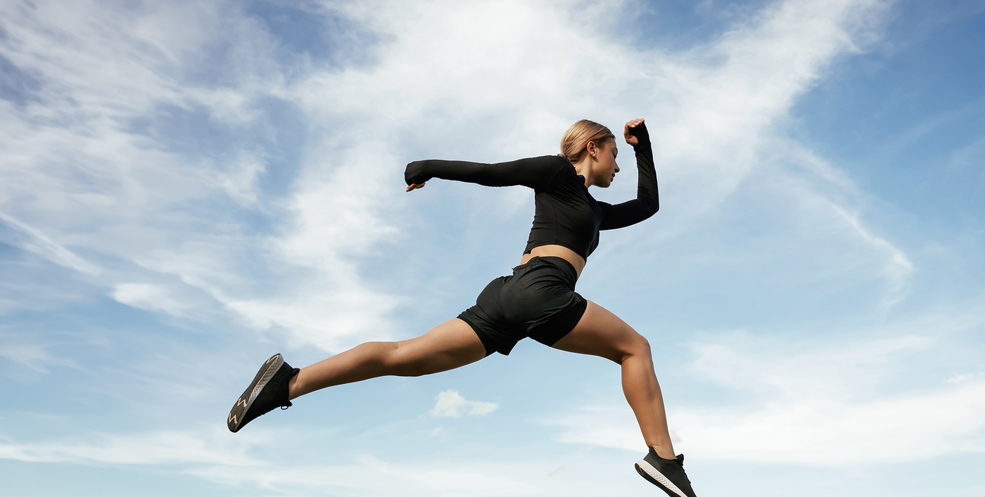 Woman athlete jumping outdoors under blue sky with bold “Your Fitness, Our Priority!” text and Boost Energy call-to-action banner promoting active lifestyle and wellness.